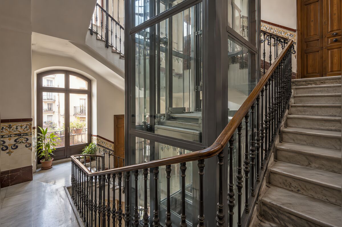 Ascensor nuevo con estructura de cristal instalado en el hueco de la escalera de un edificio
